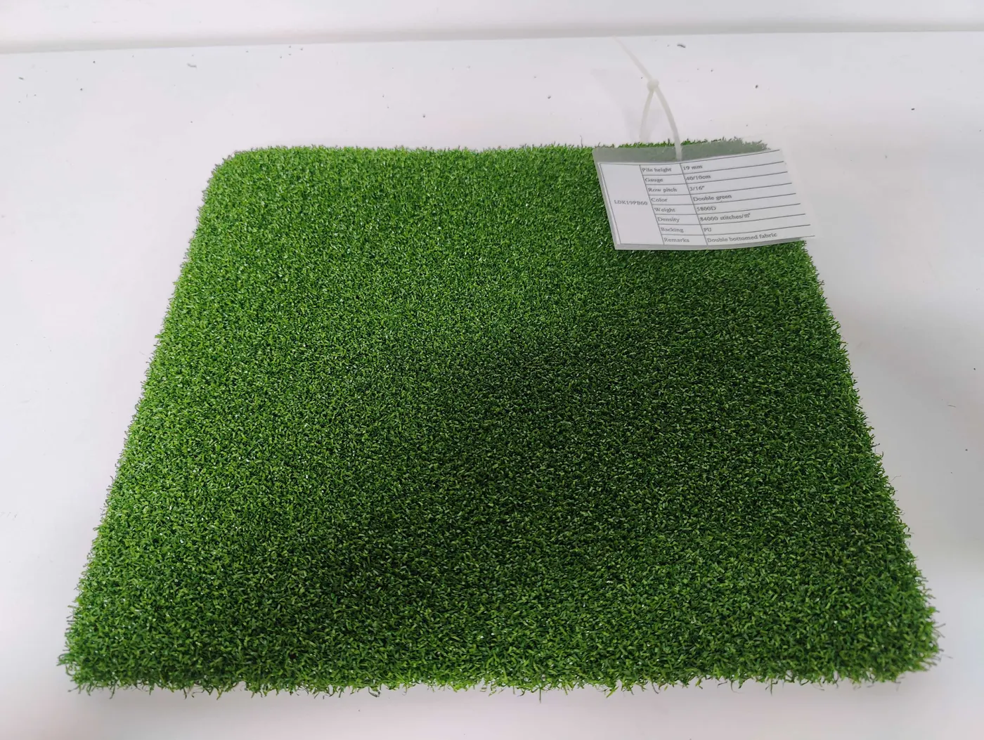 Artificial-grass surface sample with visible infill texture