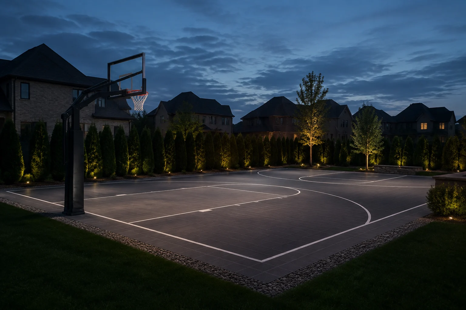 Low-glare lighting over a backyard basketball court at dusk