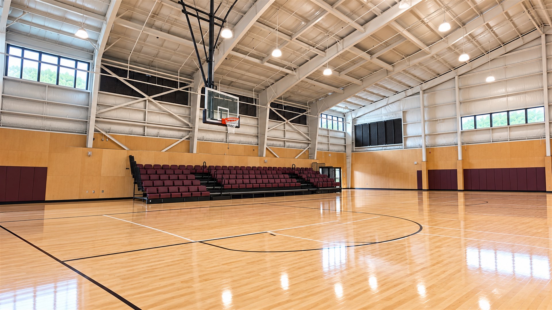 Completed gym with ceiling-suspended basketball hoop and wood floor